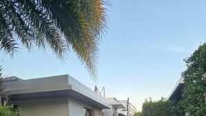 Une maison moderne avec un chemin pavé menant à l’entrée, entourée d’un espace vert bien entretenu.
