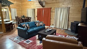 Ein Holzinterieur mit einer Couch, einem Couchtisch und einem Kamin.