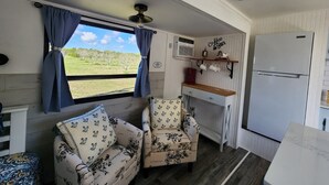 A compact kitchen with a refrigerator, a coffee bar, and two floral-patterned chairs. - 12 min to the Everglades Nat. Park & near FL Keys! Cozy RV in Redland w/laundry (Homestead)