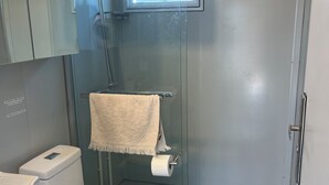 A bathroom with a toilet, sink, and shower.