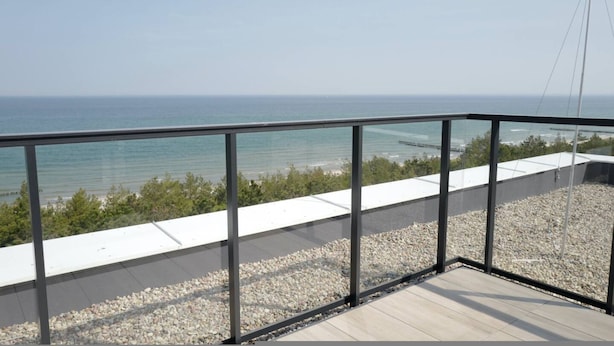 A balcony with a clear view of the sea and a distant bridge. - Widok na Morze Przy Pla y Taras Shellter (Trzebiatow)