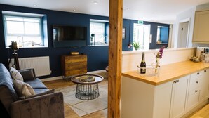 Ein modernes Wohnzimmer mit einer Couch, einem Couchtisch und einer Wand mit Holzapplikationen.