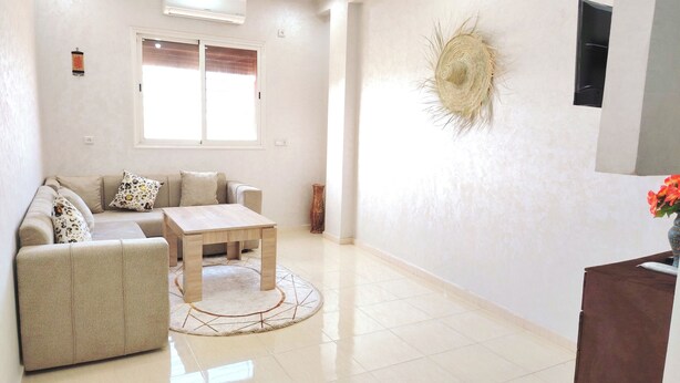 A modern living room with a sofa, a coffee table, and a decorative wall piece.