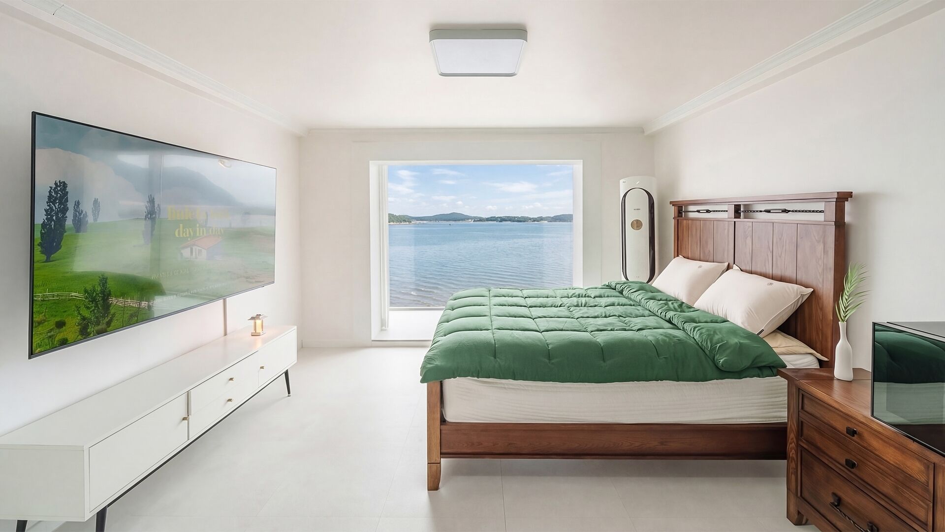 A bedroom with a bed, a TV, a dresser, and a window with a view of a lake.