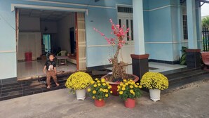 A building with a blue exterior, a door, and a staircase leading to a covered area. - Nha nghi Nguyen Bao  - Tran De Con Dao (Can Tho)