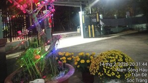 A gated entrance with decorative lights and potted plants. - Nha nghi Nguyen Bao  - Tran De Con Dao (Can Tho)