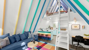 Um apartamento moderno estilo loft, com cozinha, sala de jantar e beliche.
