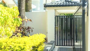 A gated entrance with a tiled pathway leading to a covered area. - Coastal Holiday Home - Bradford 10 (Labrador)