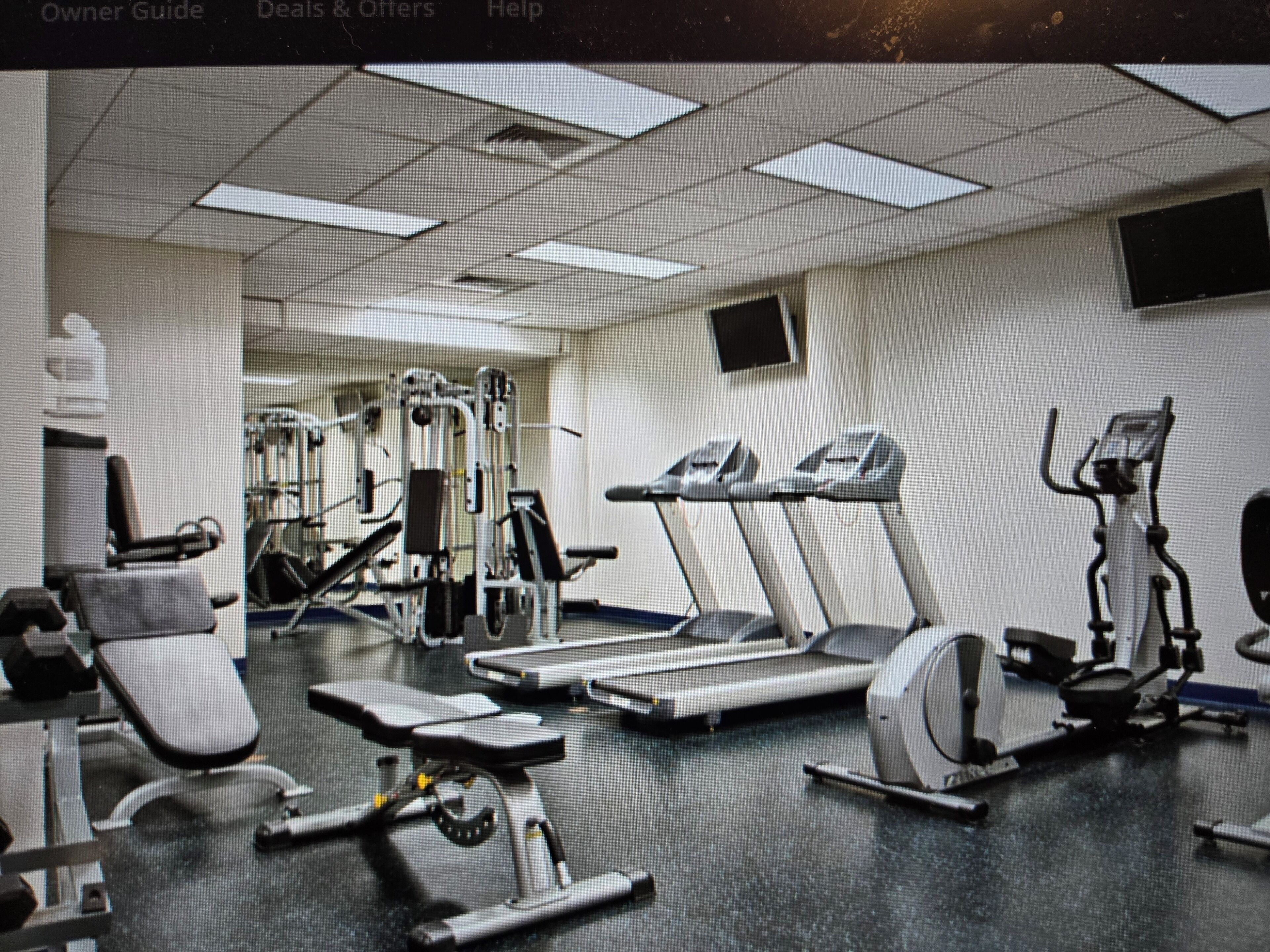 A gym with treadmills, weight machines, and a stationary bike.