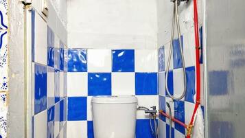 Een badkamer met toilet, douche en blauw-witte geruite tegels.
