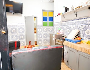 Une cuisine équipée d’une cuisinière, d’un évier et d’une fenêtre donnant sur un paysage coloré.