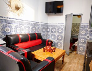 Un salon avec un canapé, une table basse et un téléviseur.