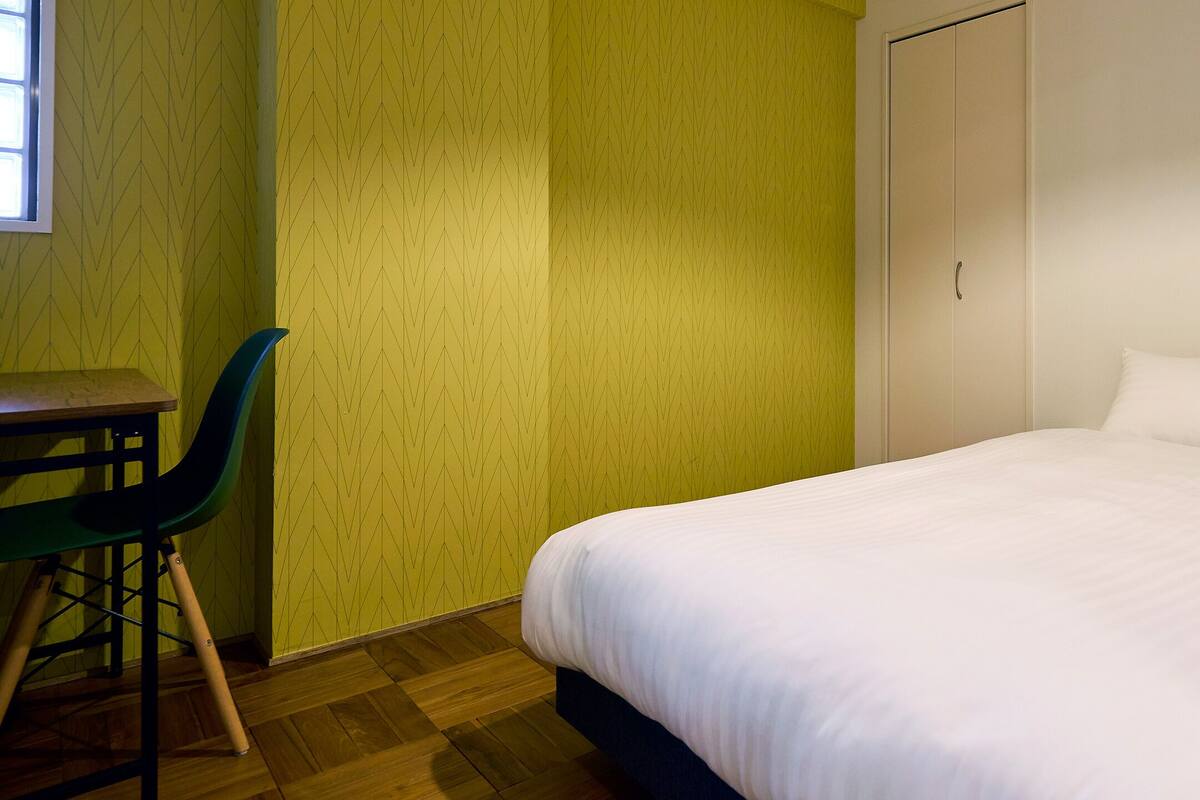A room with a bed, a desk, and a chair.