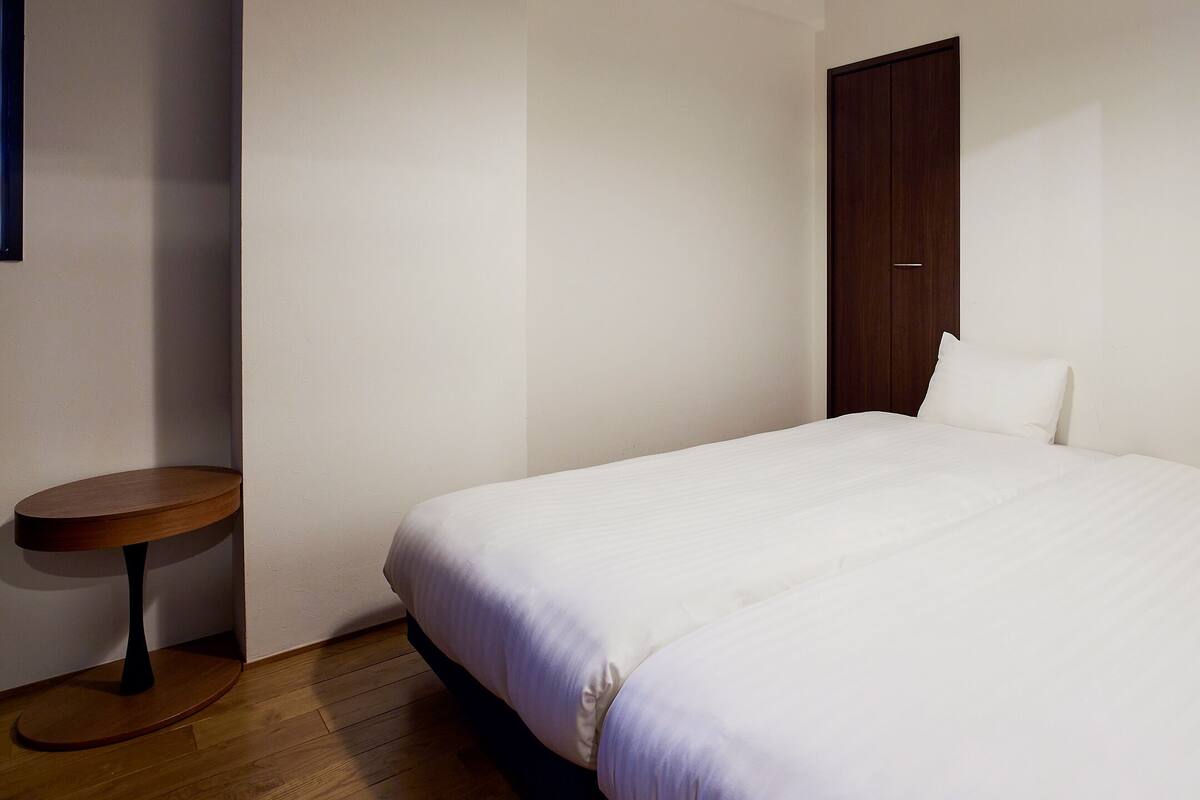 A bedroom with a bed, a small round table, and a wardrobe.
