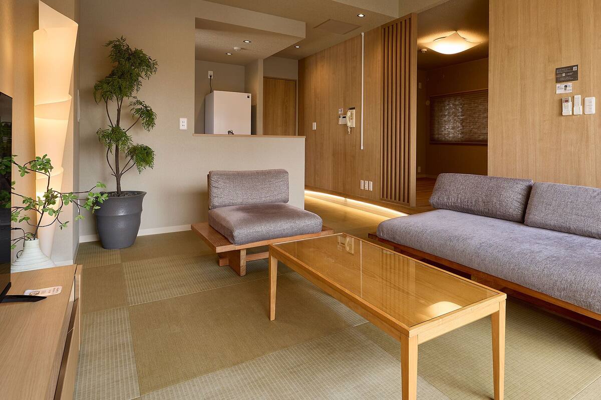 A modern living room with a sofa, a coffee table, and a small table with a plant.