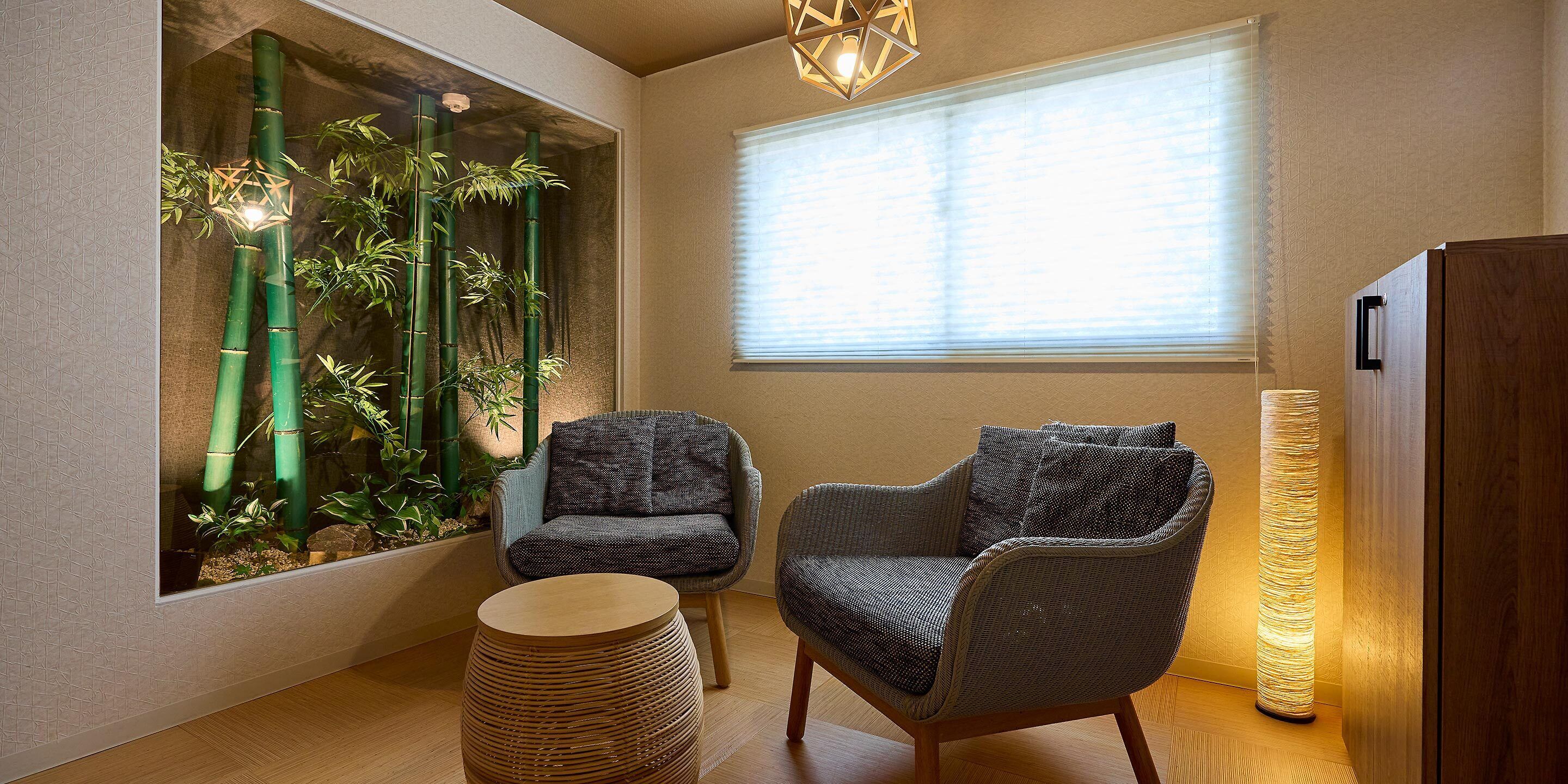 A room with a large window, a chair, a small table, and a tall lamp.