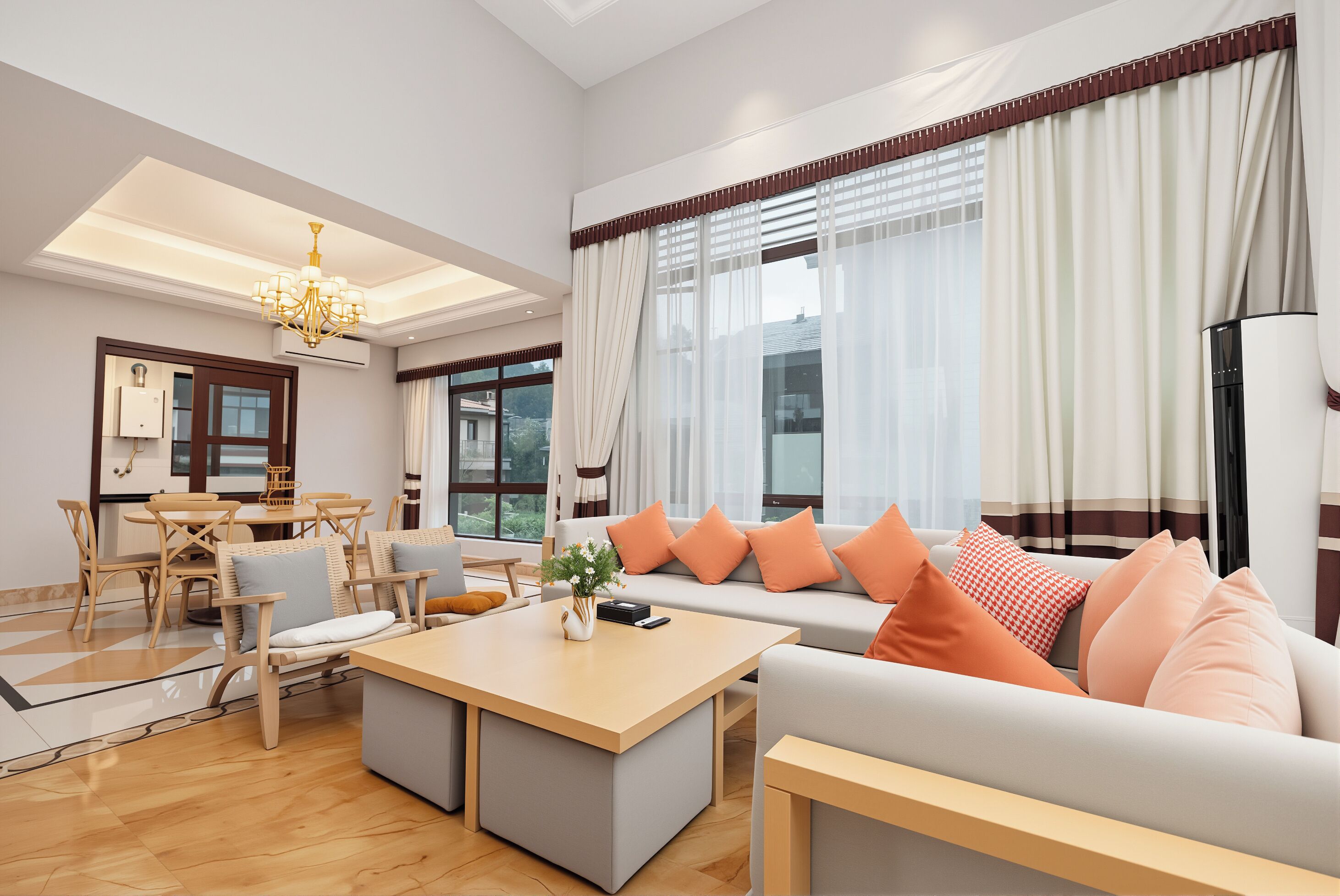 Ein modernes Wohnzimmer mit Sofa, Hocker, Esstisch, Stühlen und einer Chandelier.