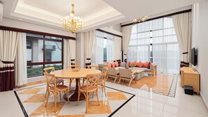 A spacious living room with a dining area, large windows, and a chandelier. - Pandora Valley Villas (Zhangjiajie)