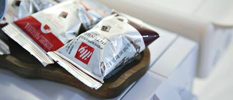 A tray with several packets of instant coffee on a wooden surface.