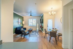 A spacious living area with a sofa, coffee table, and dining table with chairs. - San Portella (Tempe)