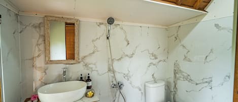 Ein Badezimmer mit Marmorwaschbecken, Toilette und Dusche.