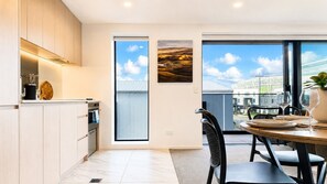 Una cocina moderna con comedor, ventanas amplias y vista a la ciudad.