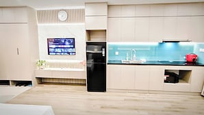 Una cocina moderna con televisión integrada, refrigerador y pileta.