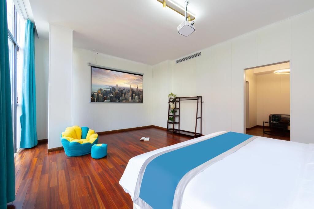 Habitación de hotel con cama, un cuadro de paisaje urbano, escritorio y silla.