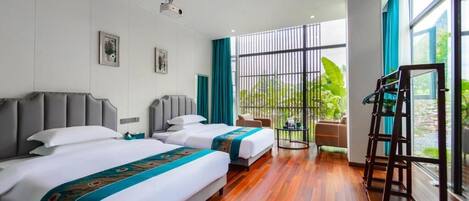 Habitación de hotel con dos camas, un ventanal grande y vistas a zonas verdes.