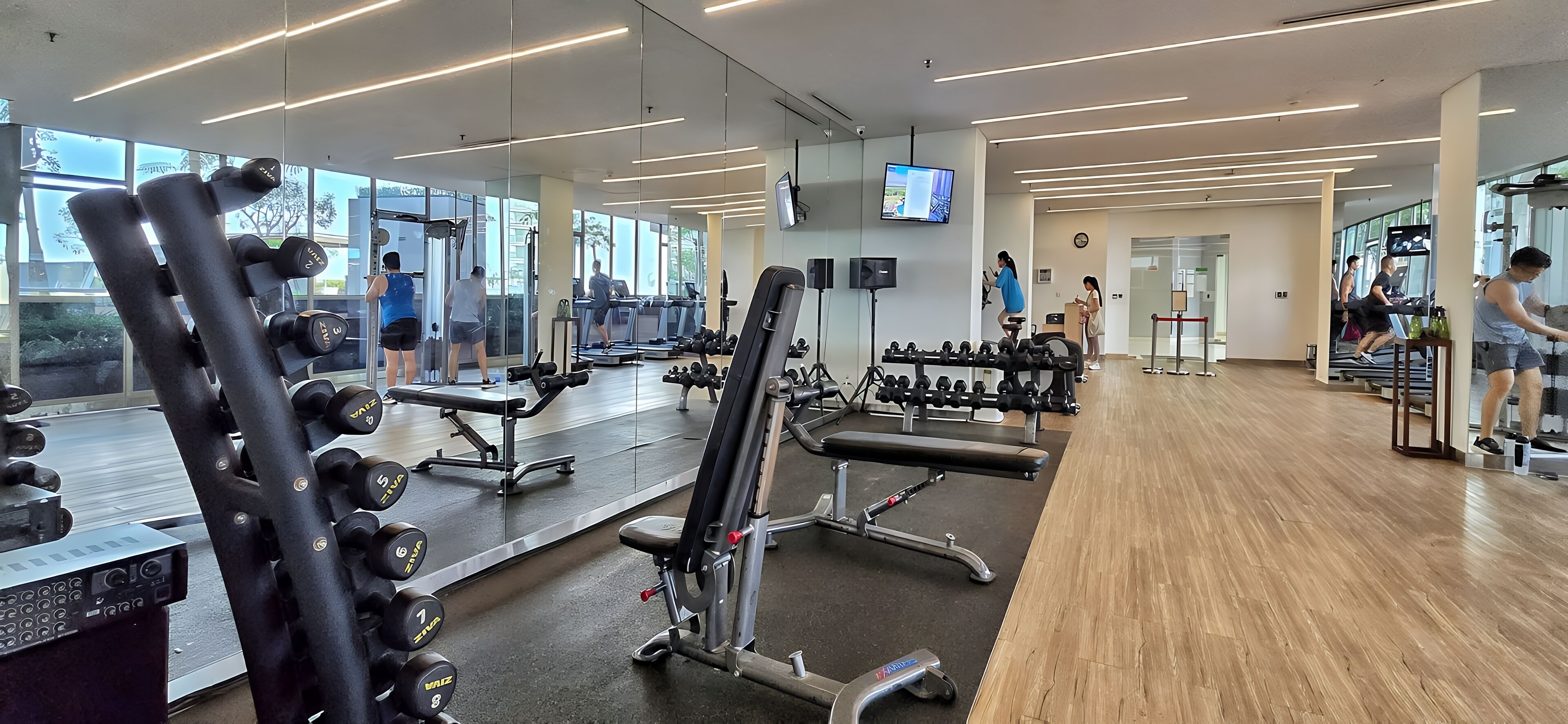 A modern gym with exercise equipment, large windows, and a clean, well-lit interior.