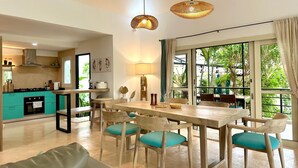 Una cocina moderna con comedor, ventanas amplias y vista a la vegetación.