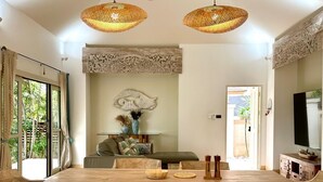Un comedor con una mesa y sillas de madera, un ventilador de techo y un adorno en la pared.