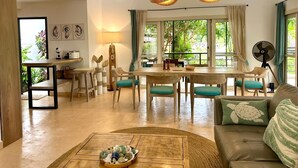 Un amplio salón con una mesa de comedor, sillas, un sofá y una mesa de centro.