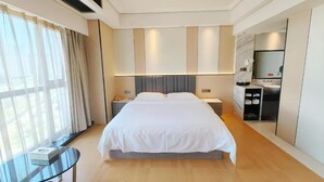 A modern hotel room with a large bed, bedside tables, a small desk, and a wardrobe. - Zhangjiajie Merlot Crystal Hotel (Zhangjiajie)