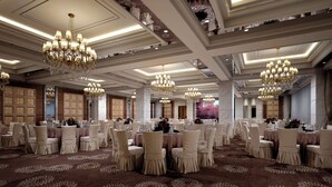 A spacious banquet hall with multiple round tables, elegant chandeliers, and a patterned carpet. - Zhangjiajie Merlot Crystal Hotel (Zhangjiajie)