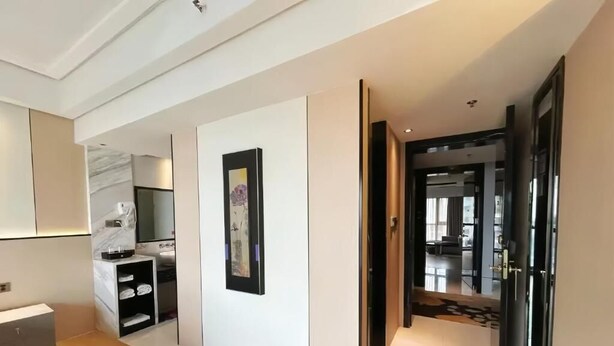A modern interior with a hallway leading to a dining area, a bathroom with a marble countertop, and a framed artwork on the wall. - Zhangjiajie Merlot Crystal Hotel (Zhangjiajie)