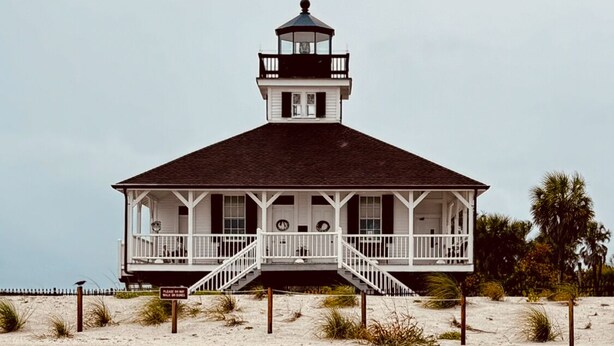 A coastal building with a balcony, a tower, and a sandy beach in the foreground. - Rare BOCA GRANDE 3BR/3BA WATERFRONT - Gulf Sunsets & Harbor Sunrises - Boat Slip (Boca Grande)