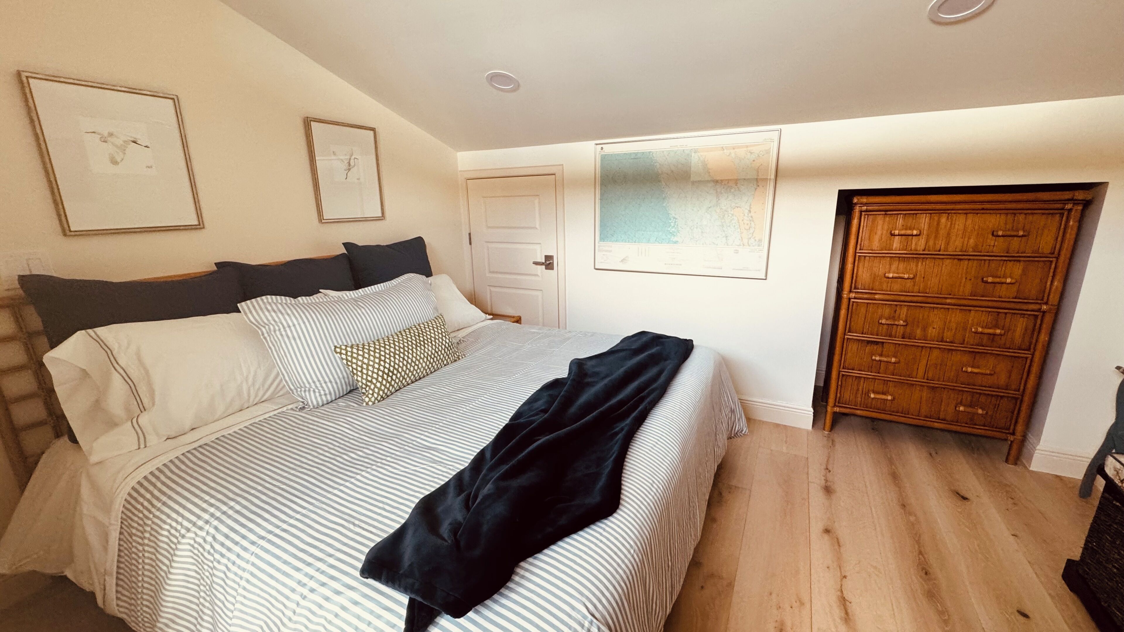 Une chambre à coucher avec un lit, une commode et une porte.