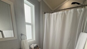 Un baño con lavamanos, inodoro y cortina de ducha.