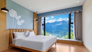 Ein Schlafzimmer mit einem Holzbett, Bergblick und einer Wandmalerei.