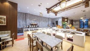 A modern restaurant with marble countertops, wooden accents, and a central island with food displays. - Friend Zhangjiajie Hotel (Zhangjiajie)