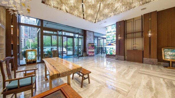 A spacious lobby with a large wooden table, chairs, and a chandelier. - Friend Zhangjiajie Hotel (Zhangjiajie)