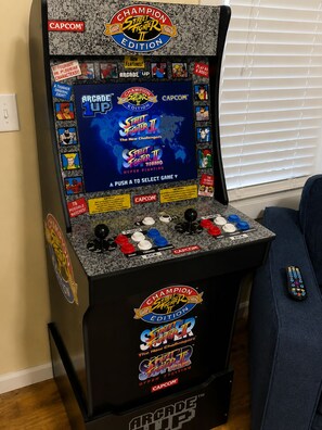 A CAPCOM arcade machine with a 'Champion Street Fighter II Edition' label, featuring a selection of games and a joystick.