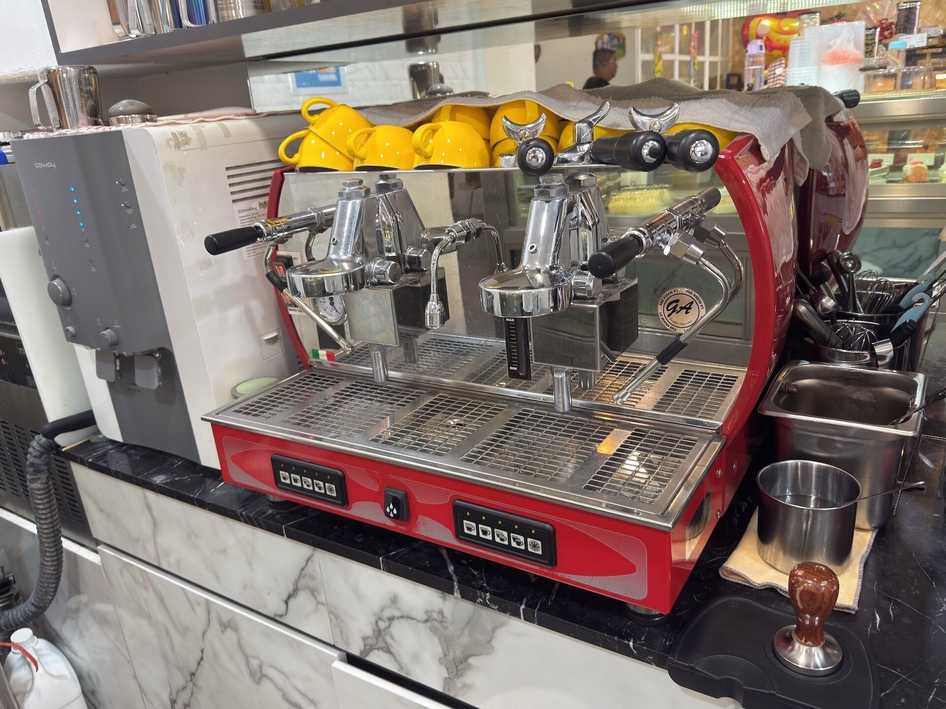 Una máquina de café con varios porta filtros, una estación para espumar leche y una boquilla de vapor.