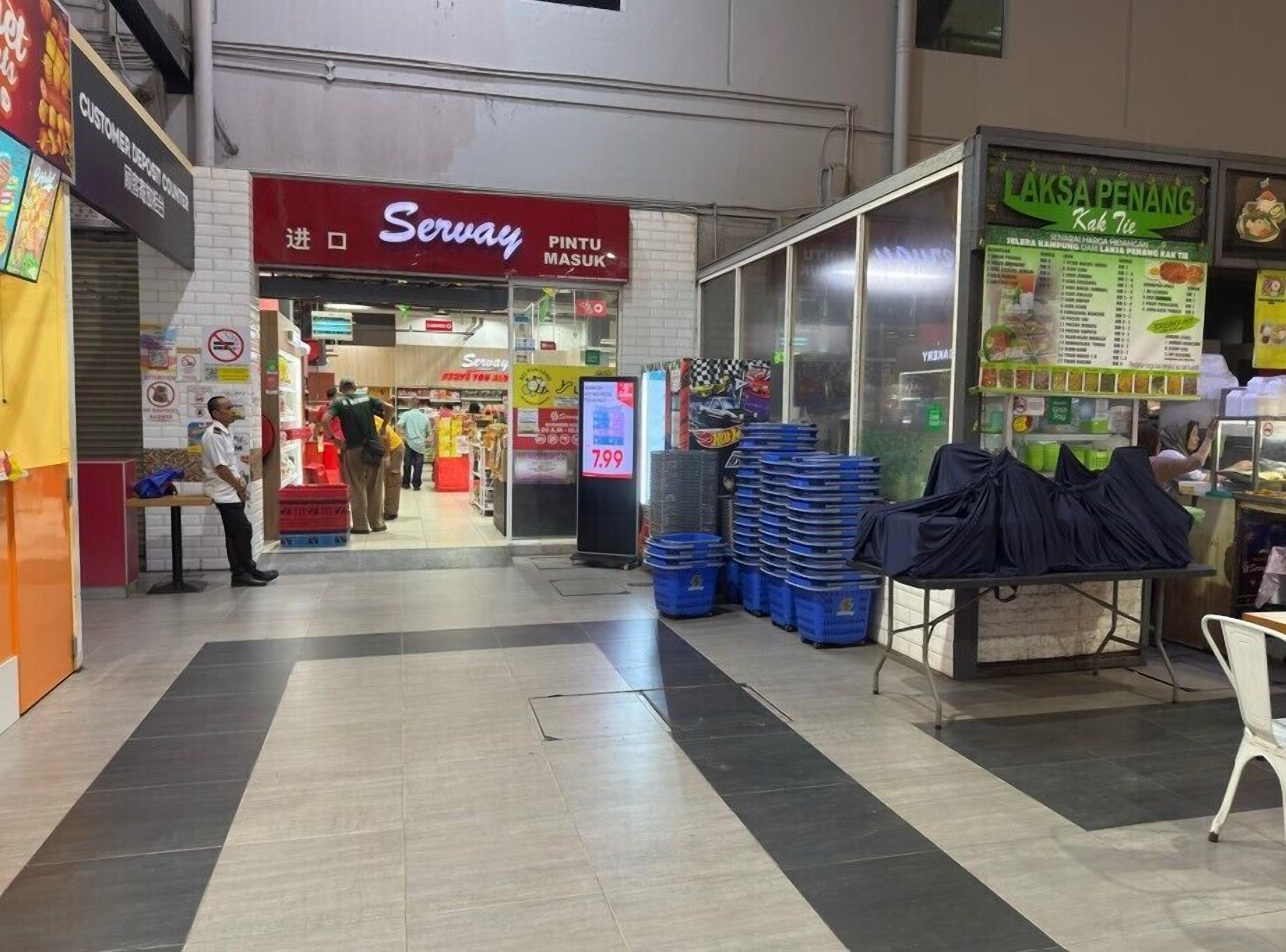 A shopping area with a Servay store, a Laksa Penang stall, and a customer service center.