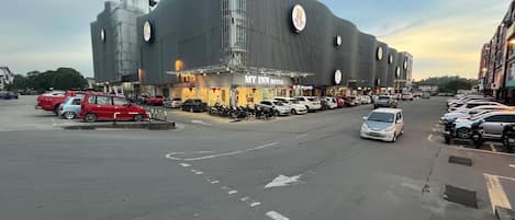 Un hotel moderno con una fachada curva distintiva, un estacionamiento con coches y un cielo despejado.