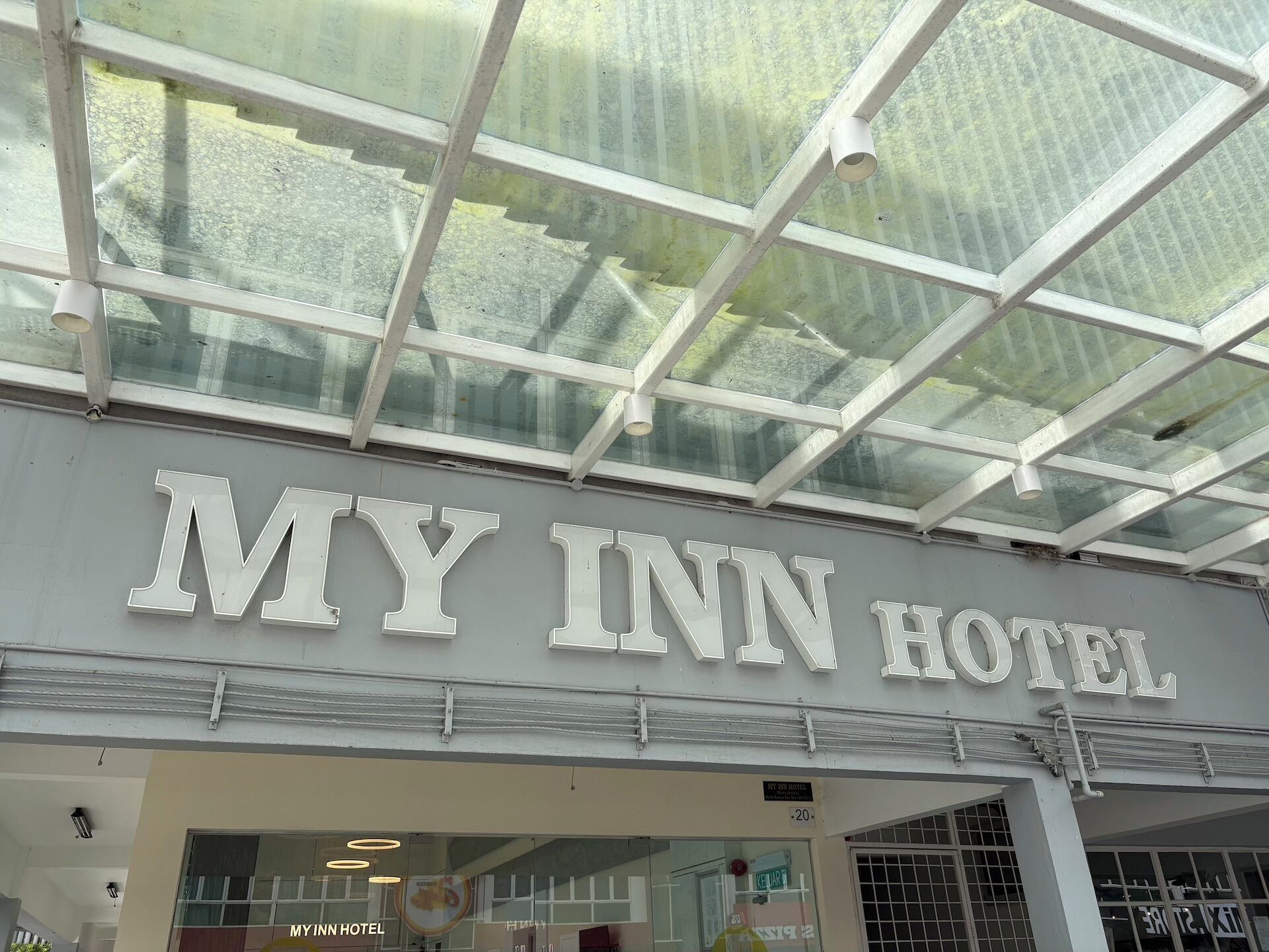 The exterior of MY INN HOTEL with a glass roof structure.
