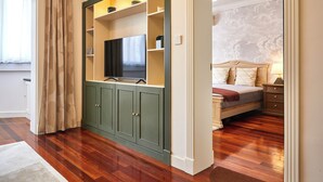 Une chambre avec un lit, une télévision et une armoire.