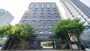 A modern hotel with a prominent entrance, multiple floors, and a clear view of the surrounding urban environment. - Hasen Nabeeya Hotel (Siheung)