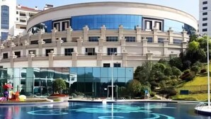 A modern building with a circular pool featuring blue water patterns. - Avatar Valley Grand Hotel (Zhangjiajie)